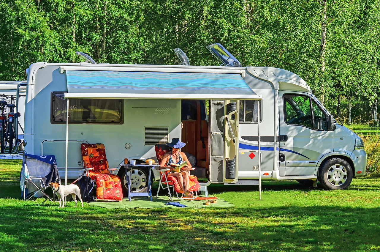 Woman reading a book in front of her RV