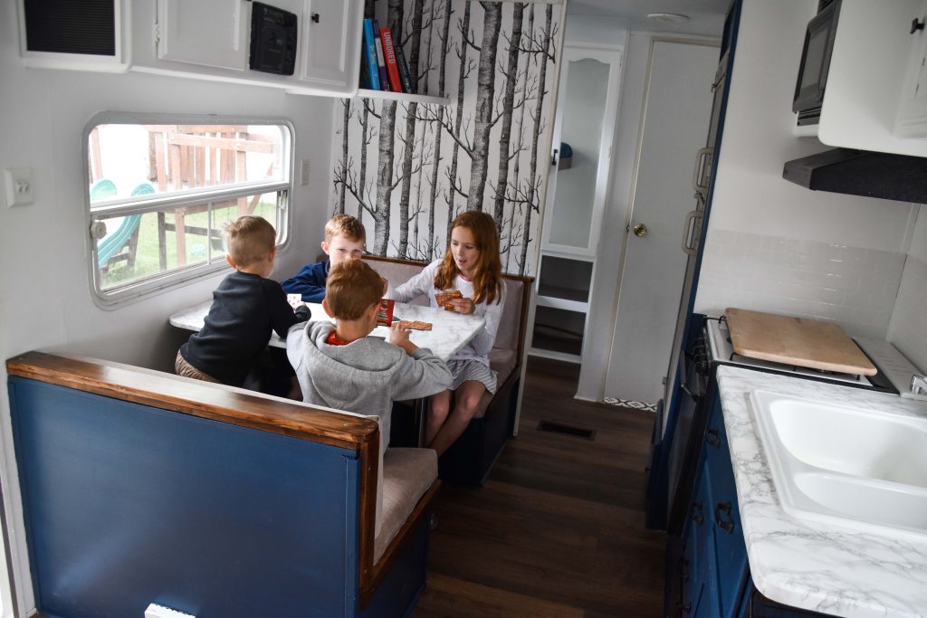 Kids eating snacks and playing cards in an RV
