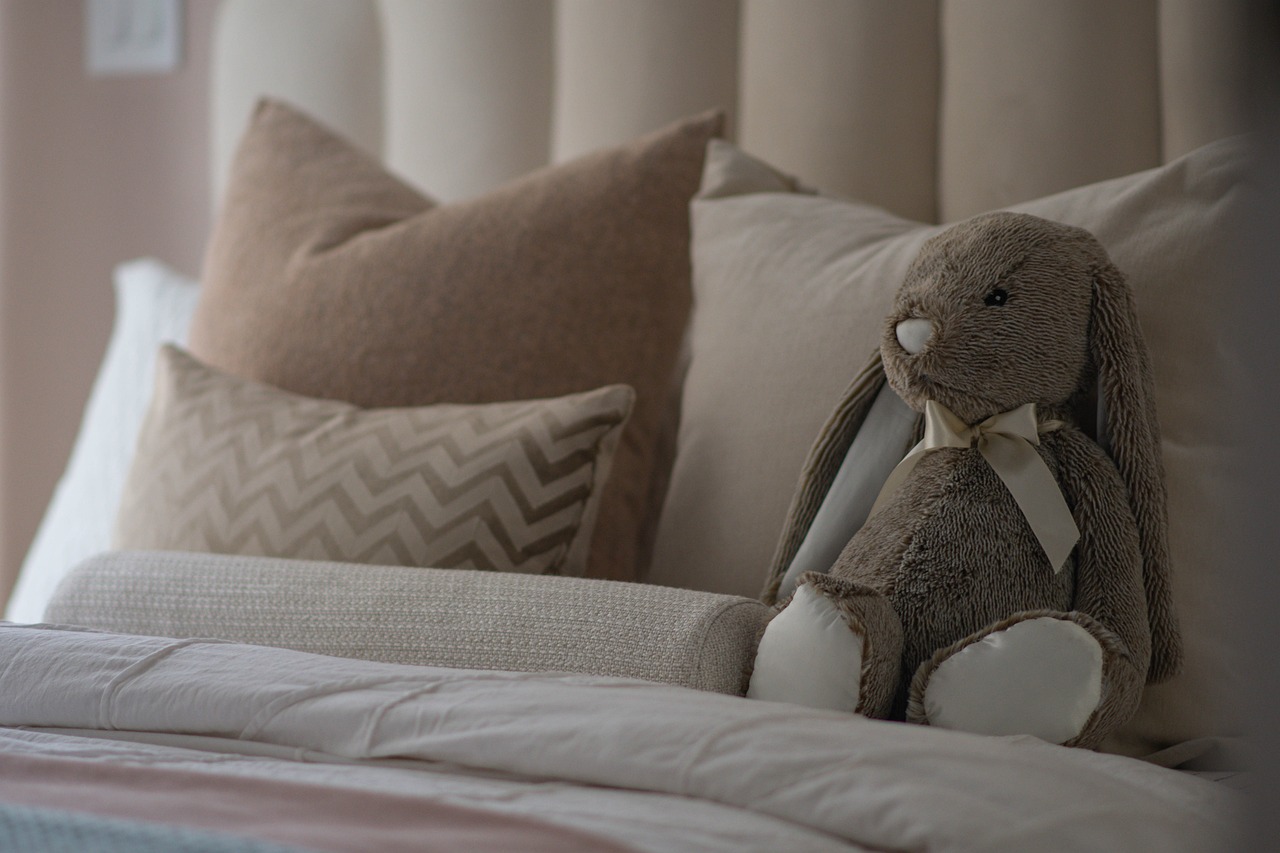 Bed with a bedspread, accent pillows and a stuffed animal